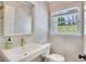 Bright bathroom featuring a designer wallpaper, stylish sink, vanity, and a window with a garden view at 770 Wellesley Nw Dr, Atlanta, GA 30305