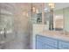 Bright bathroom features a glass shower, marble tile and counters, and blue vanity at 770 Wellesley Nw Dr, Atlanta, GA 30305
