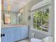 The vanity has light blue cabinets, a marble countertop, and a large window for natural light at 770 Wellesley Nw Dr, Atlanta, GA 30305