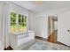 Bedroom featuring a white crib next to window with outside view and white-painted wood floor at 770 Wellesley Nw Dr, Atlanta, GA 30305