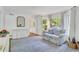 Inviting living area featuring a large window, light blue rug, and a white console with vintage mirror at 770 Wellesley Nw Dr, Atlanta, GA 30305