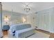 Bright bedroom showcasing hardwood floors, striped wallpaper, four-poster bed and an elegant light fixture at 770 Wellesley Nw Dr, Atlanta, GA 30305