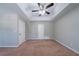 Neutral bedroom with a tray ceiling, ceiling fan and carpet flooring at 12237 Cypress Ln, Fayetteville, GA 30215