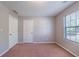 Bedroom with neutral walls, carpet, window with blinds, and two paneled doors at 12237 Cypress Ln, Fayetteville, GA 30215