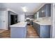 Well-lit kitchen featuring gray cabinets, a center island, and modern black appliances and wood-look flooring at 12237 Cypress Ln, Fayetteville, GA 30215