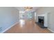 Open-concept living room featuring a brick fireplace, hardwood floors and a view into the adjacent dining room at 12237 Cypress Ln, Fayetteville, GA 30215