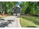 Exterior of the home with a 2-car garage, spacious driveway and lush green trees at 1435 Withmere Ln, Atlanta, GA 30338