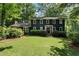 Charming two-story home with a lush green lawn and mature trees creating a serene setting at 1435 Withmere Ln, Atlanta, GA 30338