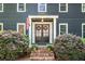 Close-up of the home's entrance, featuring a decorative door, brick steps, and manicured shrubs at 1435 Withmere Ln, Atlanta, GA 30338