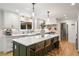 Bright kitchen boasts white cabinets, hardwood floors, large island with seating, and stainless steel appliances at 1435 Withmere Ln, Atlanta, GA 30338