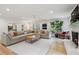 Bright living room features fireplace, hardwood floors, large sectional couch and view to the dining room at 1435 Withmere Ln, Atlanta, GA 30338
