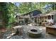 Expansive stone patio boasts a fire pit, dining area, outdoor seating, and an inviting screened porch for relaxation at 1435 Withmere Ln, Atlanta, GA 30338
