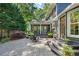 Back patio showcasing outdoor seating, stone pavers, an open porch, and access to the home's entrance at 1435 Withmere Ln, Atlanta, GA 30338