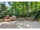 Outdoor patio features a gas grill, fire pit, stone pavers and a charming dining table set in a lush green backyard at 1435 Withmere Ln, Atlanta, GA 30338