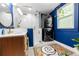 Modern bathroom features glass shower, stacked washer/dryer, and stylish blue walls at 1608 Carroll Nw Dr, Atlanta, GA 30318