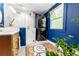 Modern bathroom features glass shower, stacked washer/dryer, stylish blue walls, and bright light at 1608 Carroll Nw Dr, Atlanta, GA 30318