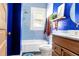 Blue bathroom featuring wood vanity, marble countertop, tub with shower, and patterned blue accent wall at 1608 Carroll Nw Dr, Atlanta, GA 30318