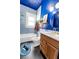 Updated blue bathroom featuring tiled walls, shower-tub combo, wood vanity, and black hexagon tile flooring at 1608 Carroll Nw Dr, Atlanta, GA 30318
