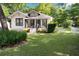 Attractive home with a welcoming front porch, lush green lawn, and mature landscaping, creating a cozy ambiance at 1608 Carroll Nw Dr, Atlanta, GA 30318