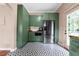 Spacious kitchen with green cabinets, stainless steel refrigerator, microwave, and black-and-white patterned flooring at 1608 Carroll Nw Dr, Atlanta, GA 30318