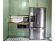 Stainless steel refrigerator and microwave in kitchen with green cabinets and geometric tile flooring at 1608 Carroll Nw Dr, Atlanta, GA 30318