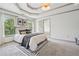 A bedroom featuring tray ceilings, carpet, and large windows at 3282 Green Farm Trl, Dacula, GA 30019
