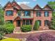 Beautiful brick home featuring stone accents and a well-manicured lawn and flowering shrubs at 3282 Green Farm Trl, Dacula, GA 30019