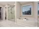 Bright bathroom with a soaking tub under a window and a glass-enclosed shower at 3652 Silvery Way, Powder Springs, GA 30127