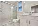 Modern bathroom with a glass-enclosed shower, white vanity, and marble-look tile at 3652 Silvery Way, Powder Springs, GA 30127