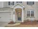 Close up showcasing the front entryway, featuring brick accents, dark blue door and manicured landscape at 3652 Silvery Way, Powder Springs, GA 30127