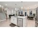 Open-concept kitchen with stainless steel appliances, a central island, and views into the dining and living areas at 3652 Silvery Way, Powder Springs, GA 30127