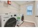 Bright laundry room features a window and modern washer and dryer appliances at 3652 Silvery Way, Powder Springs, GA 30127