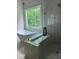 Spa-like bathroom with a soaking tub, walk-in shower with glass door, and scenic window at 5907 Sw Bunting Ln, Atlanta, GA 30331
