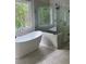 Luxurious bathroom featuring a standalone soaking tub and glass-enclosed shower at 5907 Sw Bunting Ln, Atlanta, GA 30331