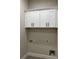 A bright laundry room with white cabinets and dark hardware at 5907 Sw Bunting Ln, Atlanta, GA 30331