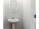 Bathroom with pedestal sink, oval mirror and modern white paint at 1227 Herty Dr, Marietta, GA 30062