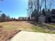 Large backyard with mature trees, wooden fence, and a storage shed at 448 Hanover Drive, Villa Rica, GA 30180
