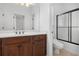 Bathroom features a vanity with dark wood cabinets and a tiled shower with glass doors at 448 Hanover Drive, Villa Rica, GA 30180