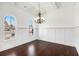 Elegant dining room with hardwood floors, wainscoting, a chandelier, and arched windows at 448 Hanover Drive, Villa Rica, GA 30180
