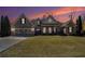 A brick facade single-story home features arched windows and a spacious green front lawn at sunset at 448 Hanover Drive, Villa Rica, GA 30180