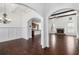 Open-concept living room featuring a stone fireplace, hardwood floors, and elegant archways at 448 Hanover Drive, Villa Rica, GA 30180