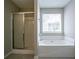 Bathroom with a glass-door shower and tub combination with a window at 4812 Browns Mill Ferry Rd, Lithonia, GA 30038