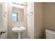Functional half bathroom showcasing a pedestal sink, mirror, and toilet against neutral-toned walls at 4812 Browns Mill Ferry Rd, Lithonia, GA 30038
