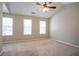 Spacious bedroom boasts vaulted ceilings, a ceiling fan, carpet floors, and natural light from multiple windows at 4812 Browns Mill Ferry Rd, Lithonia, GA 30038