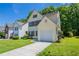 Two-story light yellow home with an attached one-car garage, well kept lawn, and a concrete driveway at 4812 Browns Mill Ferry Rd, Lithonia, GA 30038