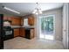 Kitchen with wooden cabinets, black appliances, and tile flooring, with glass doors leading to the backyard at 4812 Browns Mill Ferry Rd, Lithonia, GA 30038