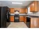 Kitchen features black appliances, wood cabinets, neutral countertops, and tile flooring at 4812 Browns Mill Ferry Rd, Lithonia, GA 30038