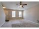 Spacious living room with neutral walls and carpet, two windows, and access to the staircase at 4812 Browns Mill Ferry Rd, Lithonia, GA 30038