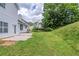 Exterior of backyard, showing a lush green lawn on sloped hill with mature trees at 4889 Hidden Creek Pl, Decatur, GA 30035