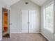 Bedroom features neutral walls, plush carpet, closet, and a sun-filled window at 4889 Hidden Creek Pl, Decatur, GA 30035